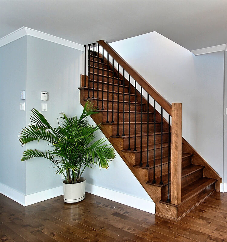 Escalier intérieur en bois avec rampe en fer forgé dans une maison