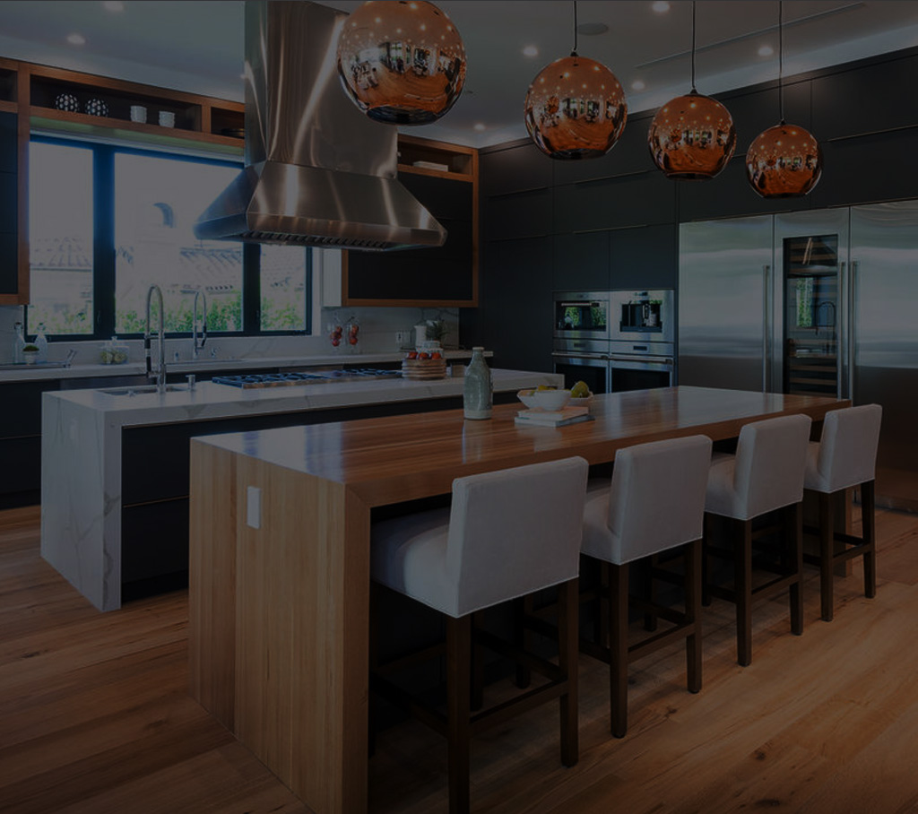 Cuisine moderne avec îlot central en bois, armoires noires et électroménagers en acier inoxydable